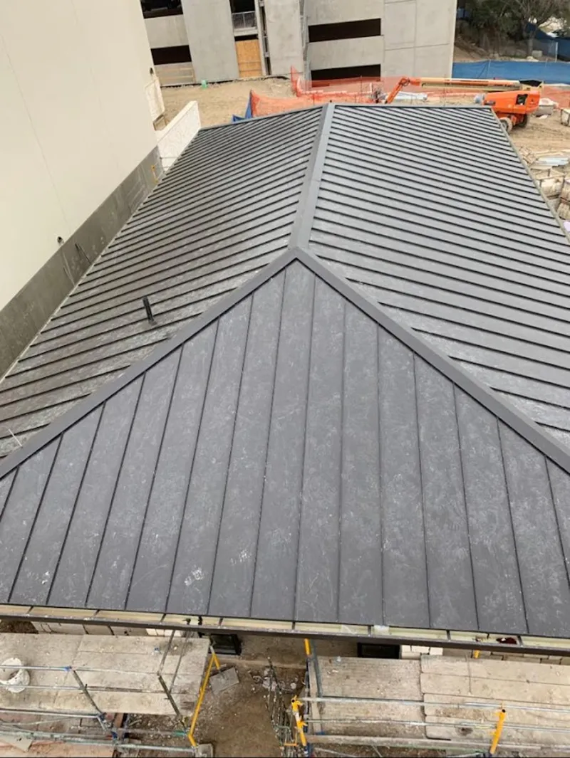 Commercial metal roof construction with crane equipment in Lander